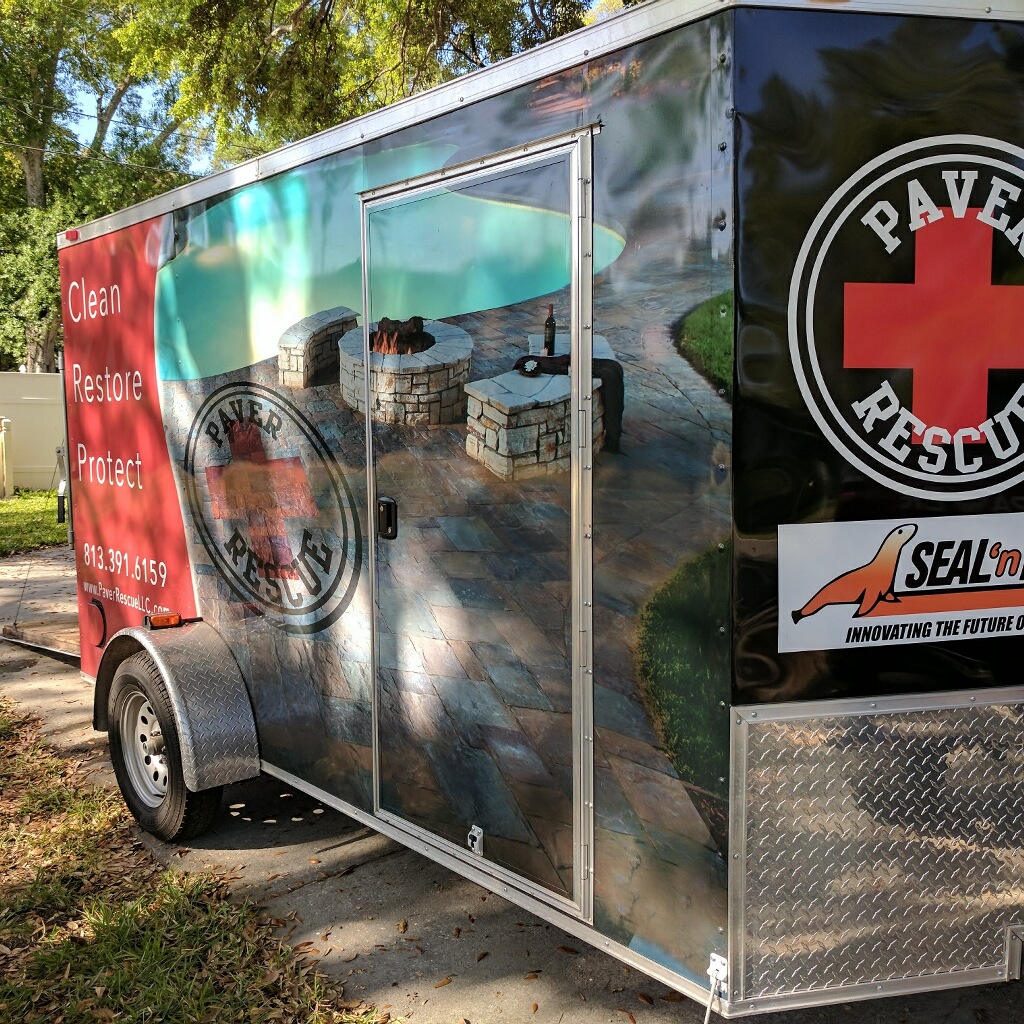 Pavers Rescue branded service trailer with wrapped graphics showing paver patio and fire pit, parked in Tampa