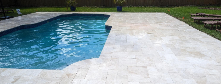 Paver pool deck with sand joint failure in Lutz FL, showing gaps needing professional stabilization before summer storms
