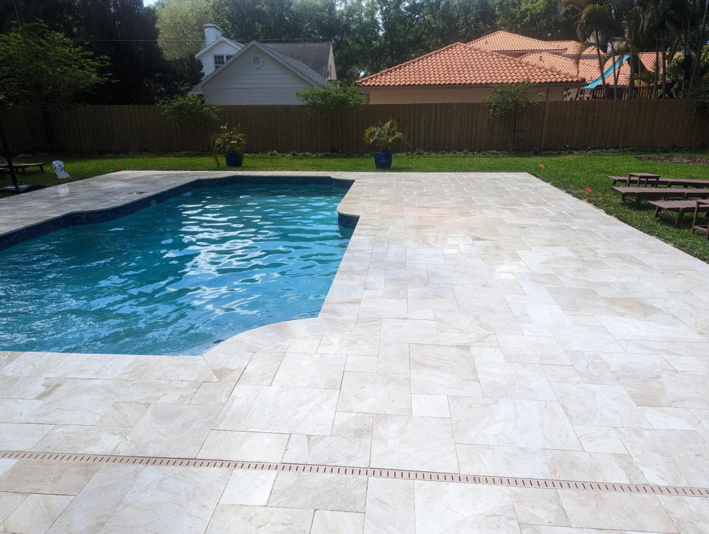 Travertine paver pool deck at a Lutz FL home showing light-colored natural stone pavers surrounding a backyard pool