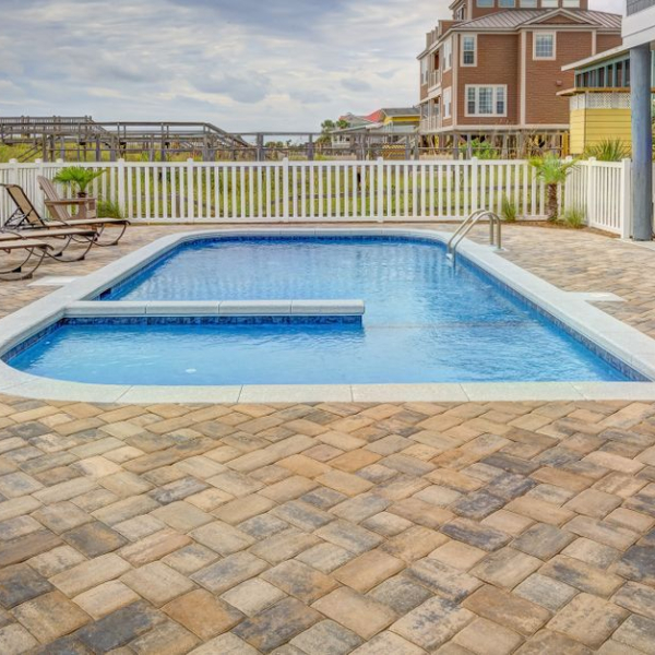 Pool deck with large brick pavers surrounding a residential swimming pool in Tampa, FL